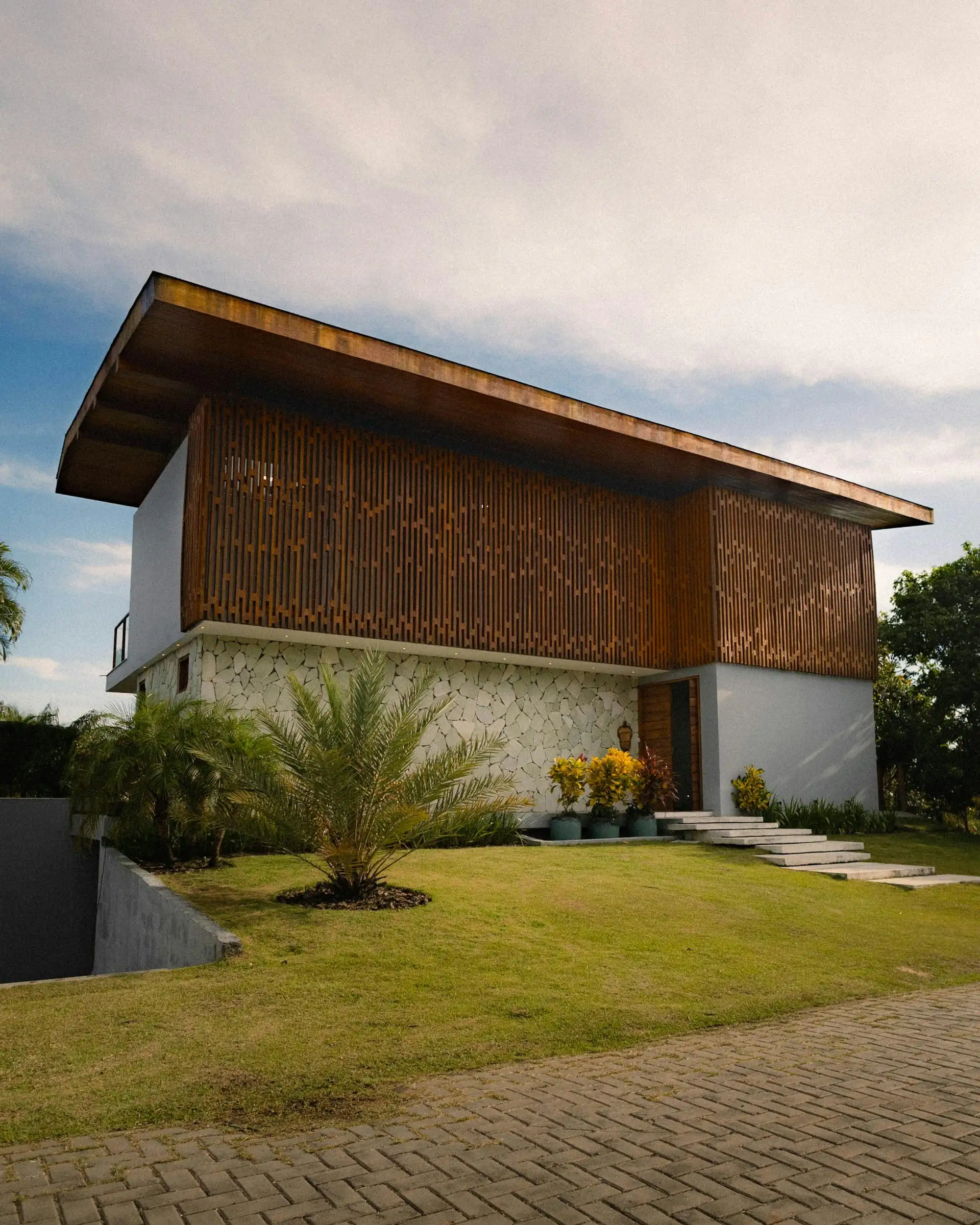 Two-storey modern house with a flat roof canopy, grey cladding and a tiled front porch