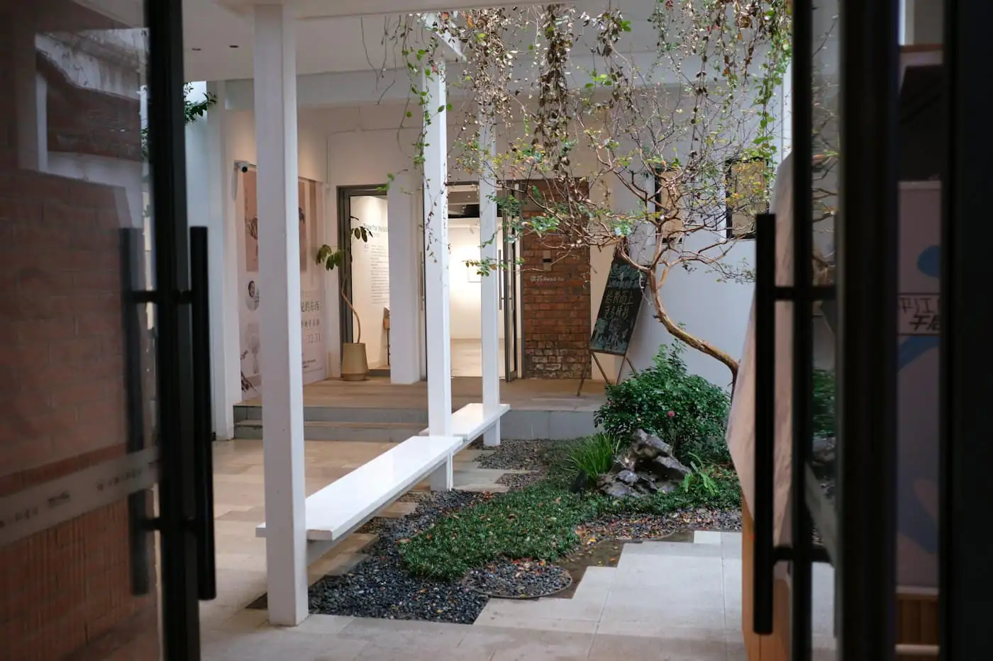 Small open courtyard with a planting bed and glass doors opening onto it