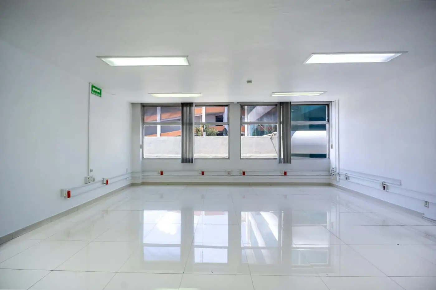 Living room with a new plaster ceiling, recessed lights and a tiled floor before furniture