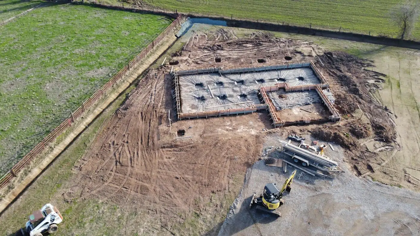 Steel reinforcement cages for pile caps in dug footing pits at a house site