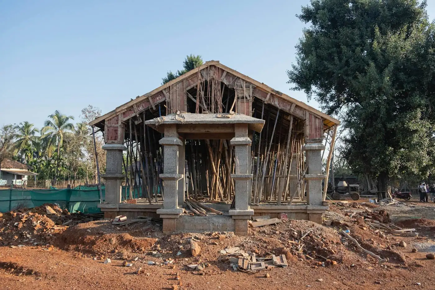 Workers fixing concrete roof tiles on timber trusses of a single-storey house