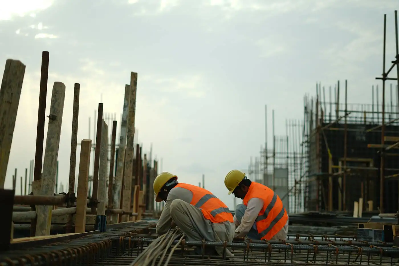 Site supervisor in a hard hat checking reinforcement on a building site