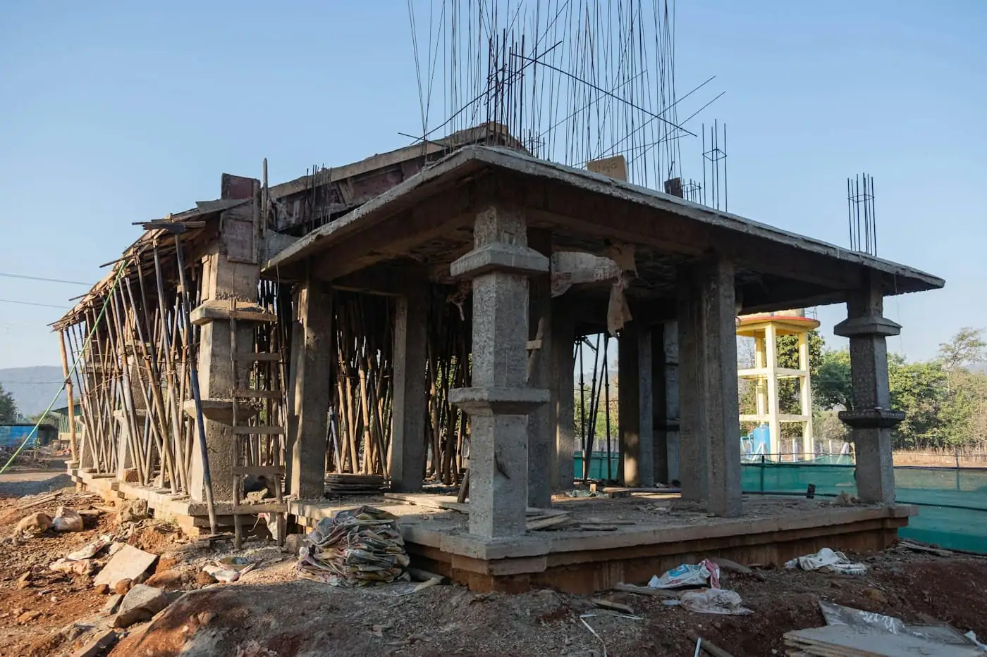 Brick walls rising between reinforced concrete columns on a house under construction